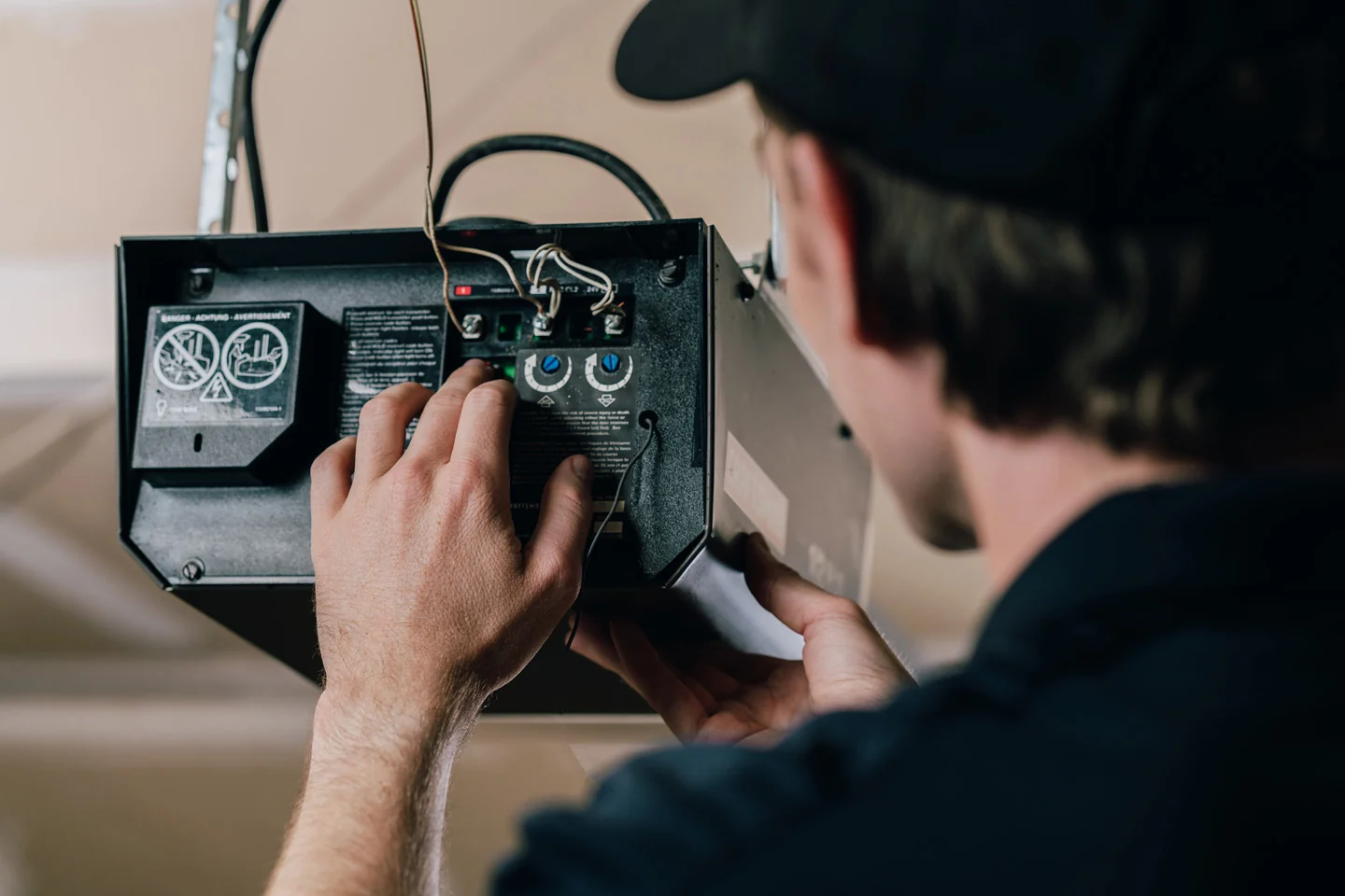Precision Garage Door technician fixing a garage door opener